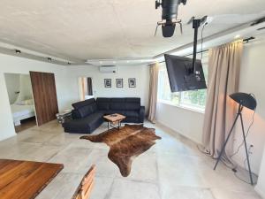 a living room with a couch and a tv and a table at Black & White - heated pool in Pula
