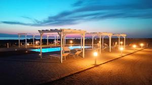 - une terrasse avec des chaises et une piscine la nuit dans l'établissement Il giardino dei tramonti, à Nardò