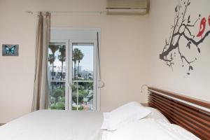 a white bedroom with a bed and a window at Mary's Maisonette in Kos