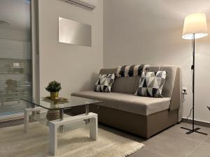 ein Wohnzimmer mit einem Sofa und einem Glastisch in der Unterkunft Apartman Panonica in Virovitica