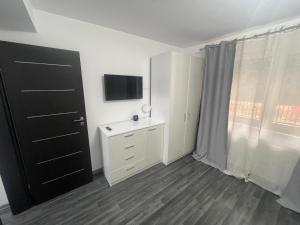 a bedroom with a white dresser and a television at BUCHAREST APARTMENTS 3 camere in Bucharest