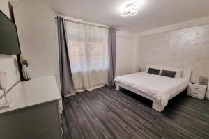 - une chambre avec un lit blanc et une fenêtre dans l'établissement BUCHAREST APARTMENTS 3 camere, à Bucarest