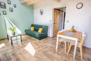 a living room with a table and a green couch at Kaszubska Lawenda Żuromino, Domek nr 3 in Żuromino