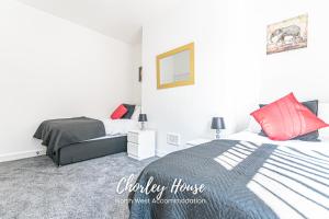 una camera da letto con un letto con cuscini rossi di Chorley Contractor Accommodation a Chorley