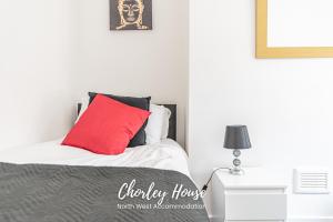 a bedroom with a bed with a red pillow at Chorley Contractor Accommodation in Chorley