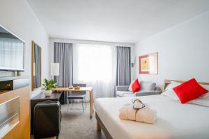 a hotel room with a bed and a desk at Novotel Glasgow Centre in Glasgow +102 photos