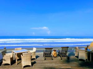 a group of chairs and tables on a beach at Beachfront Villa Nixie and the Sea Tabanan in Tabanan