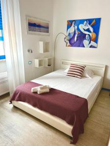um quarto com uma grande cama branca e um cobertor roxo em Hotel La Favorita em Cala Gonone