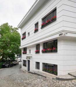 a white building with red flowers in windows at Bright Modern New 1bed1bath Hidden Gem Bebek! #78 in Istanbul