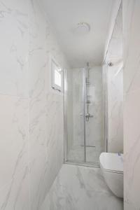 a white bathroom with a shower and a toilet at Bright Modern New 1bed1bath Hidden Gem Bebek! #78 in Istanbul