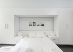 ein weißes Schlafzimmer mit einem Bett und weißen Schränken in der Unterkunft Newly Designed Central Modern Smart Duplex! #143 in Istanbul