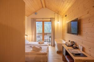 a bedroom with two beds and a sink and a tub at Giallo Dolomiti Wellness in Pieve di Cadore