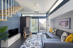 uma sala de estar com um sofá e uma televisão em Bright Modern Design New Duplex Loft Patio! #145 em Istambul