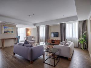 sala de estar con 2 sofás y TV en Ramada Plaza By Wyndham Kahramanmaras, en Kahramanmaraş