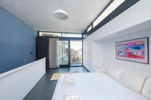 um quarto com uma grande cama branca e uma janela em Bright Modern Design New Duplex Loft Patio! #145 em Istambul