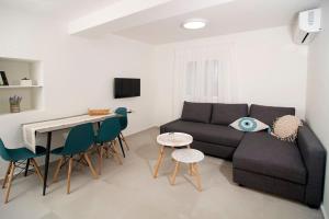 a living room with a couch and a table and chairs at G&K House Garden in Messini