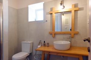 a bathroom with a sink and a toilet and a mirror at Pappou in Kinion