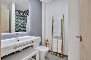 a white bathroom with a sink and a toilet at 2 terraces apartment w/ astonishing views. in Costa de Antigua +23 photos