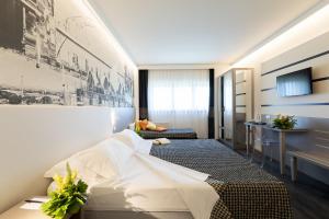 a hotel room with a large bed and a desk at The Sydney Hotel in Bologna