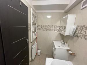 a bathroom with a white toilet and a black door at ARKADIA 2 BR APARTMENTs in Bucharest +35 photos
