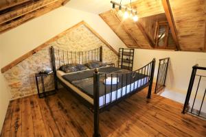 a bedroom with a black bed in a attic at Stone House Chico in Ljubuški +42 photos