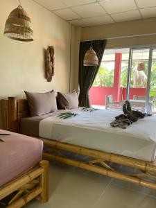 1 dormitorio con 2 camas y ventana en Mythai Guesthouse, en Chaloklum
