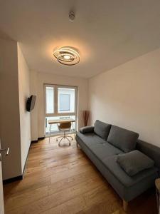 ein Wohnzimmer mit einem Sofa und einem Schreibtisch in der Unterkunft Ferienwohnung am Goitzschesee in Pouch