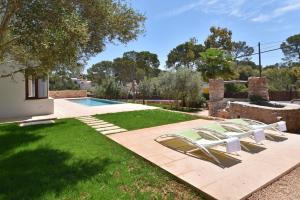 a yard with two lounge chairs and a swimming pool at Villa Chalet Porto Petro in Portopetro