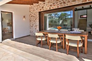 una sala da pranzo con tavolo e sedie in legno di Villa Chalet Porto Petro a Portopetro