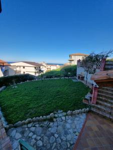 a grassy yard with a stone path and a building at I giardini del castello in Mandatoriccio Marina