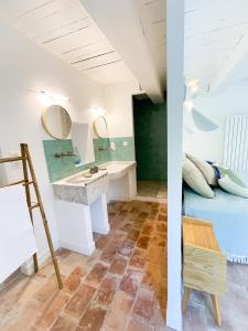 a bathroom with a bed and a sink in a room at Superbe Mas Authentique du Luberon Courroussouvo in Oppède