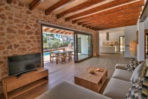 a living room with a couch and a tv and a table at Villa Chalet Porto Petro in Portopetro