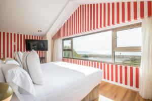 a bedroom with a red and white striped wall at Hotel Barú in Sagunto