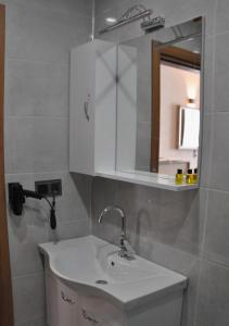 a bathroom with a white sink and a mirror at SIRT BUTİK HOTEL in Akcaabat