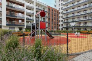 Stunning Family Apartment Ursynów with Parking & Balcony by Noclegi Renters في وارسو: ملعب أمام مبنى سكني كبير +12 صورة