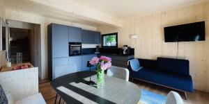 法克湖的住宿－Naturel Chalet am Faaker See，客厅配有桌子和蓝色沙发