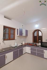 a large kitchen with gray and white appliances at Serenity Villa and Treehouse in Palakkad