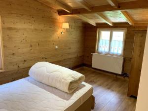 Sarrogna的住宿－Cabane Sarrogna - Lac de Vouglans，卧室配有白色的床和窗户。