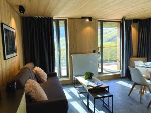 uma sala de estar com um sofá e uma mesa em Lagrange Vacances L’Écrin du Badet em Aragnouet