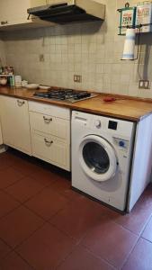 een keuken met een wasmachine en een fornuis bij Casa Melissa Fregene Airport in Fregene