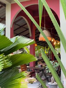 a patio with a table and palm trees at Mythai Guesthouse in Chaloklum