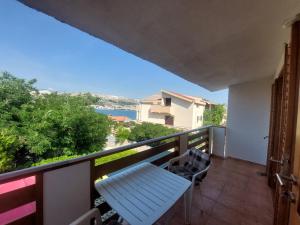 a balcony with a bench and a view of the water at Studio-app Iva, balcony with sea view - 50 m from beach in Pag
