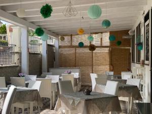 a restaurant with tables and chairs and lanterns on the ceiling at Villino Gregoraci Relais in Santa Marinella