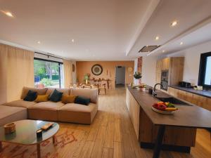 a large living room with a couch and a kitchen at Villa 5 étoiles piscine chauffée 8 pers 'Casa Sista' by Casa FAMILIA Ardèche in Sampzon