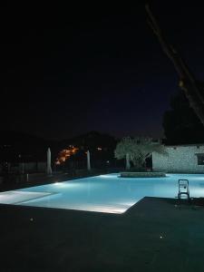 a swimming pool at night with a chair in it at hotel gans in Cascia