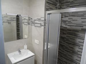 W łazience znajduje się umywalka i prysznic. w obiekcie Albergue Roma w mieście Pola de Lena
