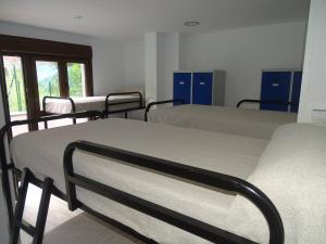 a hospital room with three beds and a window at Albergue Roma in Pola de Lena