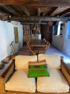 a couch with a green pillow on it in a room at Casa Fulanita in Cabezuela
