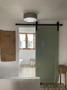 a door to a bathroom with a toilet and a window at Casa Fulanita in Cabezuela