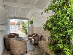 patio con sedie in vimini e parete di Villa Giulia By Cala Salento a Torre Lapillo